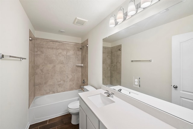 full bath with vanity, toilet, shower / washtub combination, visible vents, and wood finished floors
