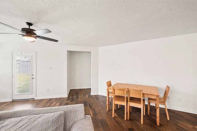 dining area featuring baseboards, wood finished floors, ceiling fan, and a textured ceiling
