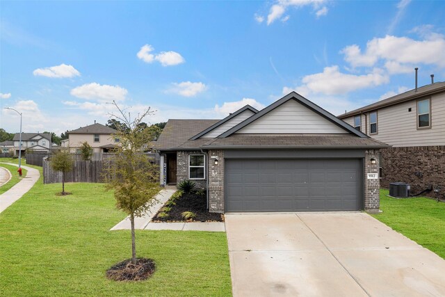 single story home featuring fence, driveway, a front yard, brick siding, and a garage