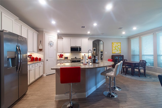 1627 Carriage Oaks Ln, Katy, TX 77494 - kitchen with arched walkways, a sink, ornamental molding, and stainless steel appliances