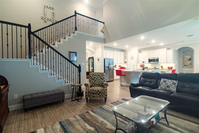 1627 Carriage Oaks Ln, Katy, TX 77494 - living room featuring arched walkways, baseboards, ornamental molding, and wood finished floors