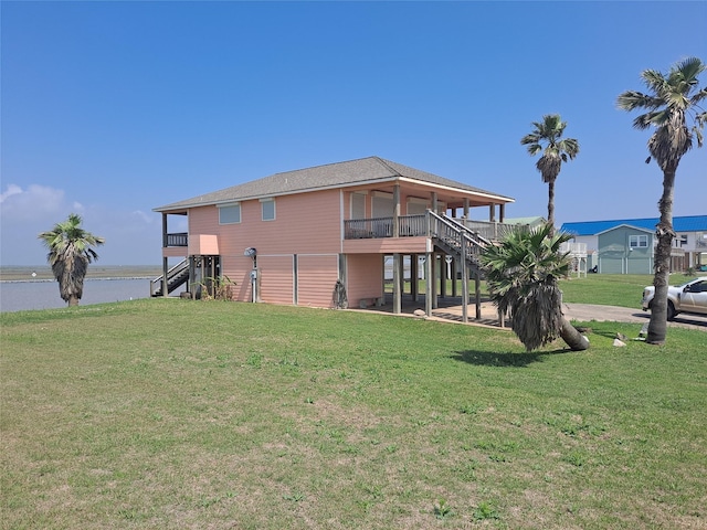 exterior space featuring stairs, a water view, and a lawn