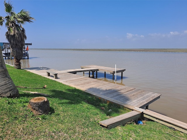 view of dock featuring a water view and a yard