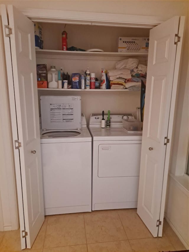 washroom with independent washer and dryer, laundry area, and light tile patterned floors