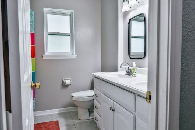 full bath featuring toilet, tile patterned flooring, a sink, and a healthy amount of sunlight