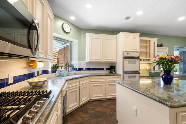 12510 Beauline Abbey St, Tomball, TX 77377 - kitchen featuring decorative backsplash, stainless steel appliances, visible vents, and a sink