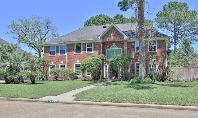 12510 Beauline Abbey St, Tomball, TX 77377 - view of front of home with a shingled roof, brick siding, a front lawn, and fence
