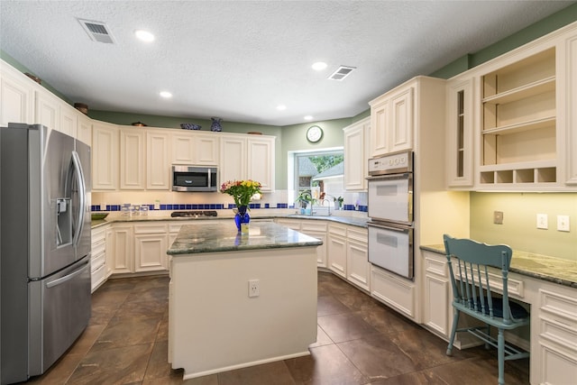 12510 Beauline Abbey St, Tomball, TX 77377 - kitchen featuring stone counters, stainless steel appliances, visible vents, and a center island