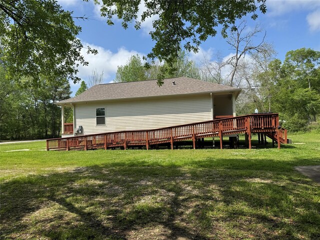 208 County Road 308, Cleveland, TX 77327 - rear view of house with a shingled roof, a wooden deck, and a yard
