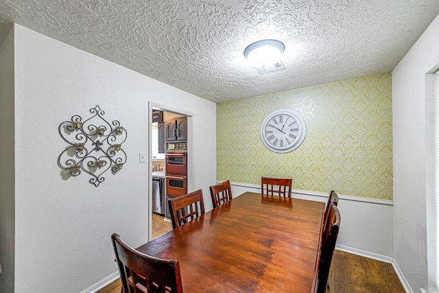 3102 Blue Hills Dr, Missouri City, TX 77459 - dining space featuring a textured ceiling, visible vents, baseboards, wallpapered walls, and wood finished floors