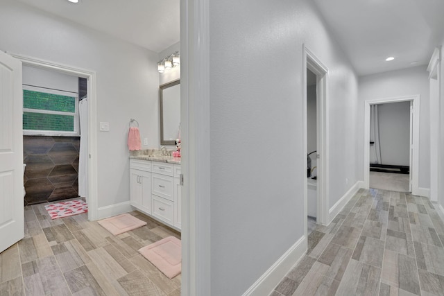 2711 Constantine St, New Caney, TX 77357 - hall featuring a sink, recessed lighting, baseboards, and light wood finished floors