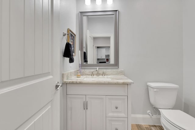 2711 Constantine St, New Caney, TX 77357 - bathroom featuring toilet, vanity, baseboards, and wood finished floors