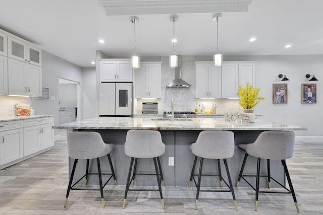 2711 Constantine St, New Caney, TX 77357 - kitchen featuring refrigerator, wall chimney exhaust hood, decorative backsplash, a sink, and recessed lighting