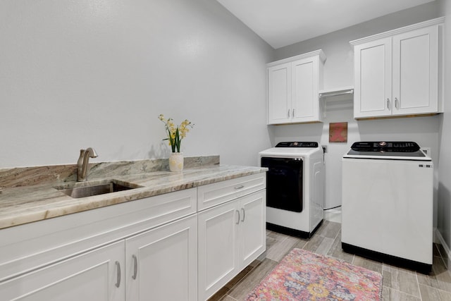 2711 Constantine St, New Caney, TX 77357 - clothes washing area featuring washing machine and dryer, cabinet space, and wood tiled floors