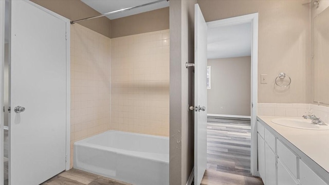 1302 20th St, Huntsville, TX 77340 - bathroom with wood finished floors, vanity, and tub / shower combination