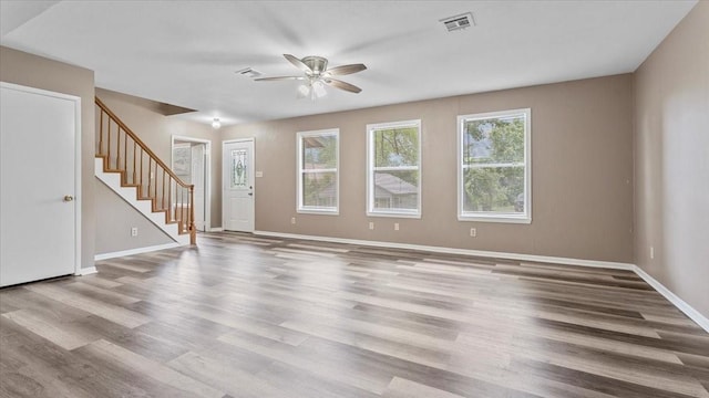 1302 20th St, Huntsville, TX 77340 - unfurnished living room featuring ceiling fan, stairway, wood finished floors, and baseboards