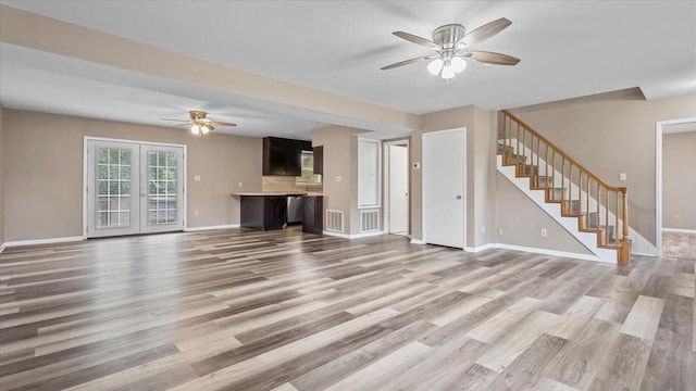 1302 20th St, Huntsville, TX 77340 - unfurnished living room featuring ceiling fan, stairs, light wood-type flooring, and baseboards