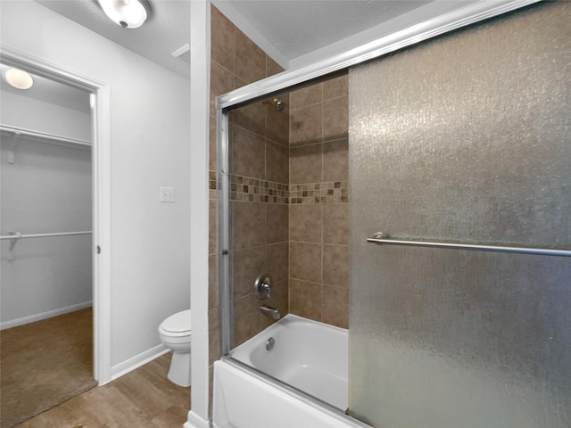 19431 Cypress Royal Dr, Katy, TX 77449 - full bathroom with enclosed tub / shower combo, toilet, wood finished floors, and a walk in closet