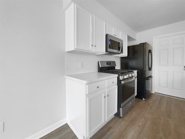 19431 Cypress Royal Dr, Katy, TX 77449 - kitchen with stainless steel appliances, wood finished floors, white cabinetry, and light countertops