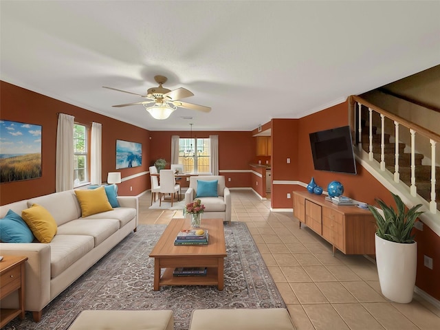 living room with light tile patterned flooring, stairs, a wealth of natural light, and a ceiling fan