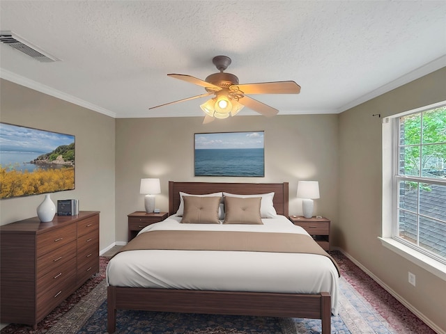 bedroom featuring baseboards, visible vents, ornamental molding, and a textured ceiling