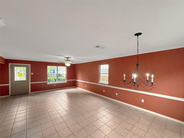 unfurnished room featuring ceiling fan with notable chandelier, visible vents, baseboards, and a healthy amount of sunlight