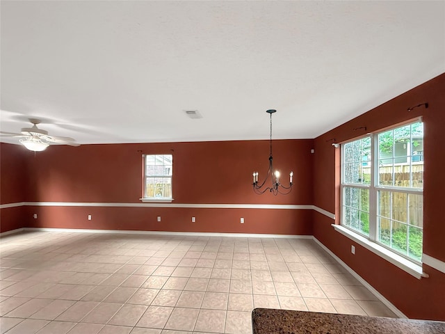 spare room featuring light tile patterned floors, baseboards, and a wealth of natural light