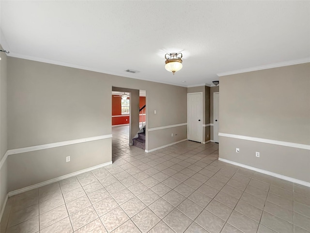 spare room with crown molding, stairway, baseboards, light tile patterned flooring, and visible vents