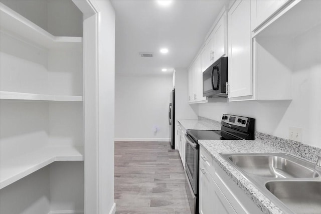 9566 Windswept Ln Unit 9566, Houston, TX 77063 - kitchen featuring stainless steel appliances, white cabinetry, recessed lighting, light wood-style floors, and light countertops