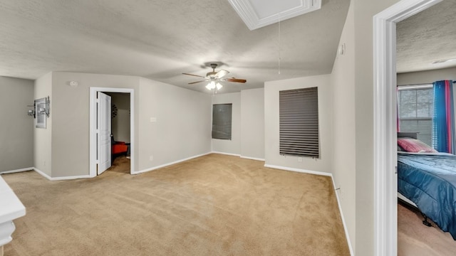 2201 Moonstone Ct, Texas City, TX 77591 - unfurnished bedroom with attic access, light carpet, baseboards, a textured ceiling, and a ceiling fan