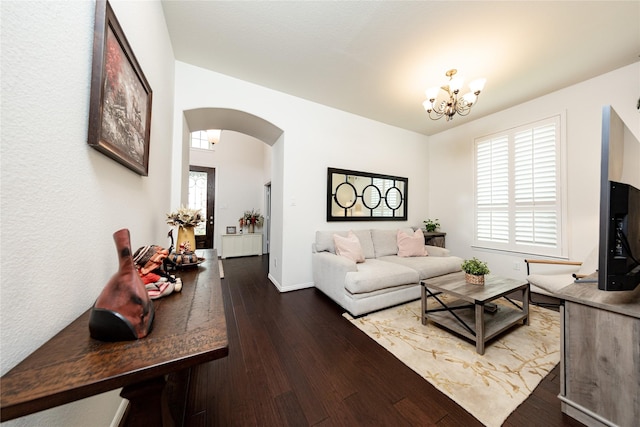6014 Barrett Cove Ct, Richmond, TX 77407 - living room featuring arched walkways, baseboards, hardwood / wood-style flooring, and a notable chandelier