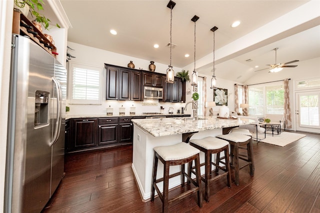 6014 Barrett Cove Ct, Richmond, TX 77407 - kitchen featuring dark brown cabinets, ceiling fan, a sink, stainless steel appliances, and vaulted ceiling