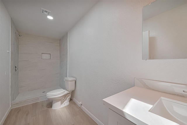 6219 Canada Dr, Pasadena, TX 77505 - full bathroom with visible vents, toilet, wood finished floors, vanity, and tiled shower