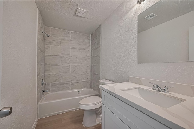 6219 Canada Dr, Pasadena, TX 77505 - full bathroom featuring a textured ceiling, visible vents, toilet, wood finished floors, and a textured wall