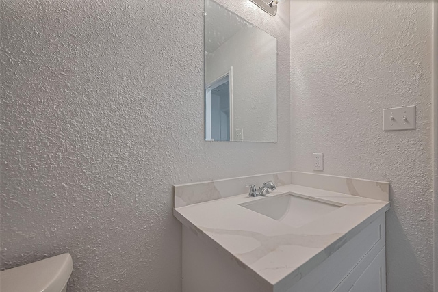 6219 Canada Dr, Pasadena, TX 77505 - bathroom featuring toilet, vanity, and a textured wall