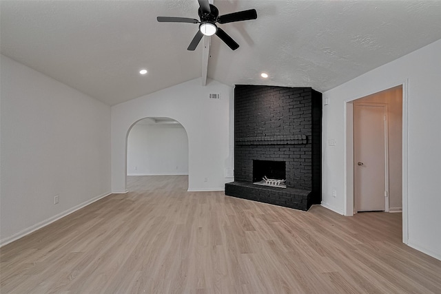6219 Canada Dr, Pasadena, TX 77505 - unfurnished living room with a ceiling fan, light wood finished floors, lofted ceiling with beams, a brick fireplace, and visible vents