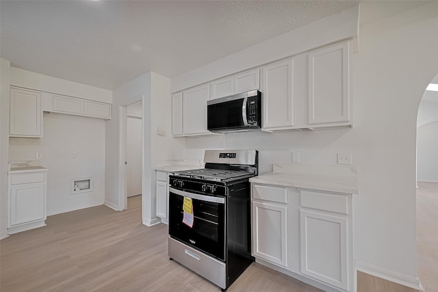 6219 Canada Dr, Pasadena, TX 77505 - kitchen with white cabinetry, arched walkways, and appliances with stainless steel finishes