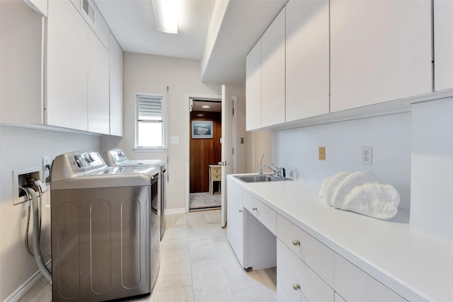 laundry area featuring a sink, visible vents, baseboards, separate washer and dryer, and cabinet space