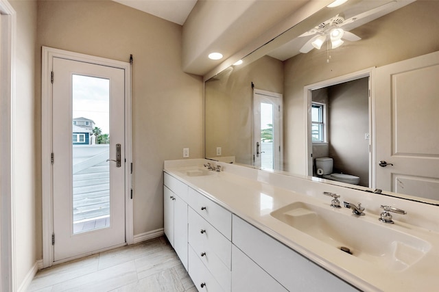 full bathroom with a healthy amount of sunlight, toilet, and a sink