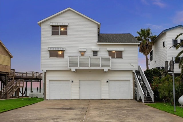 301 Isles End Rd, Tiki Island, TX 77554 - view of front of property featuring stairway, roof with shingles, driveway, and an attached garage