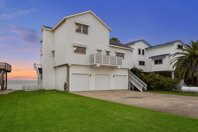 301 Isles End Rd, Tiki Island, TX 77554 - view of front of home with an attached garage, a front lawn, concrete driveway, a water view, and a balcony