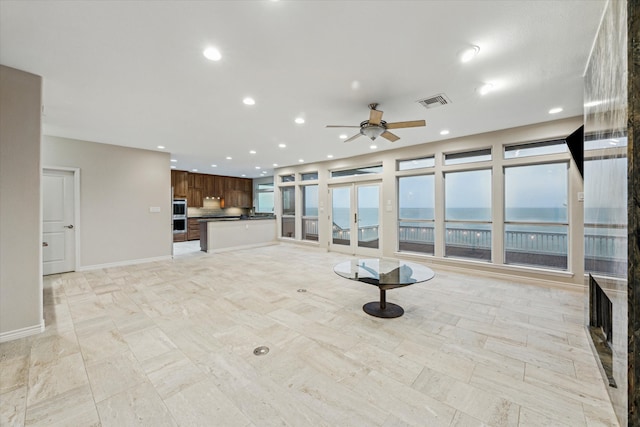 301 Isles End Rd, Tiki Island, TX 77554 - unfurnished living room featuring french doors, ceiling fan, recessed lighting, a water view, and baseboards