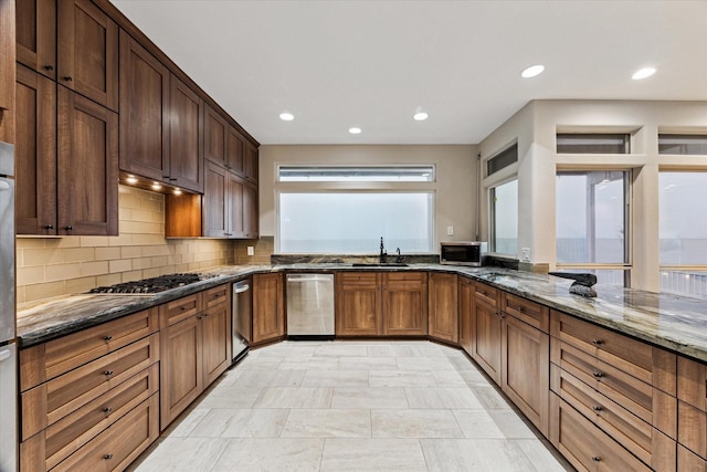 301 Isles End Rd, Tiki Island, TX 77554 - kitchen with stainless steel appliances, a sink, dark stone countertops, recessed lighting, and tasteful backsplash