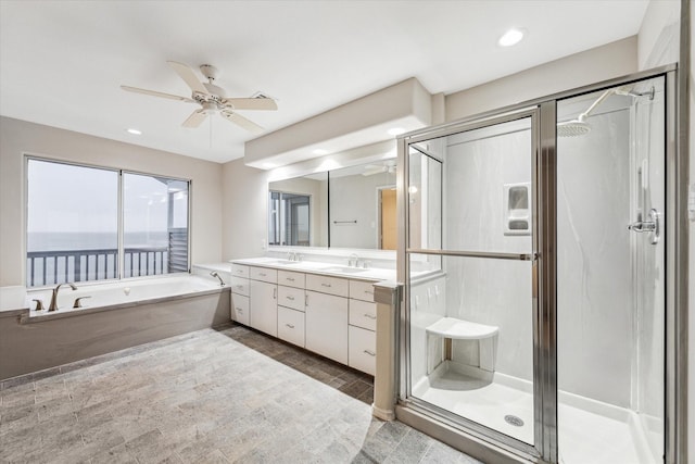 301 Isles End Rd, Tiki Island, TX 77554 - bathroom with double vanity, a bath, ceiling fan, a stall shower, and recessed lighting