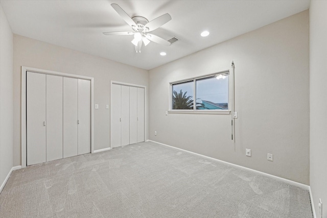 301 Isles End Rd, Tiki Island, TX 77554 - unfurnished bedroom with two closets, carpet, baseboards, recessed lighting, and ceiling fan