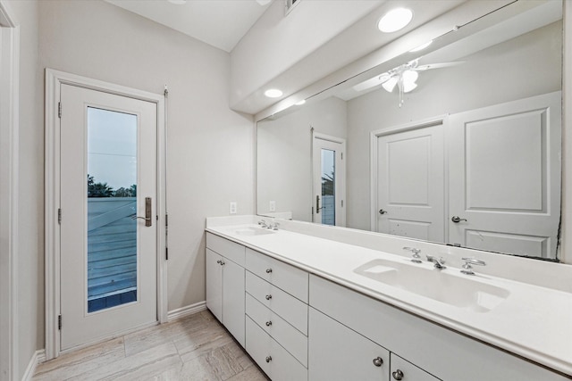 301 Isles End Rd, Tiki Island, TX 77554 - bathroom with double vanity, ceiling fan, baseboards, and marble look tile flooring