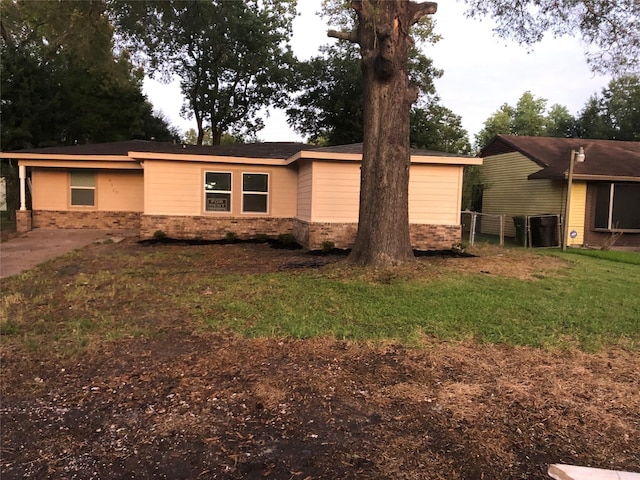 view of property exterior featuring fence, brick siding, and a yard