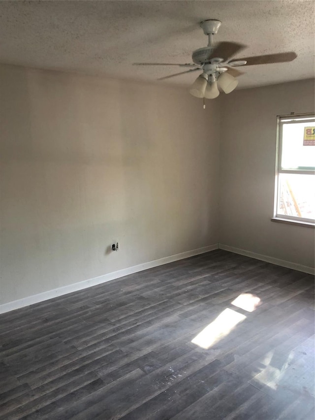 unfurnished room featuring a textured ceiling, dark wood-style flooring, ceiling fan, and baseboards