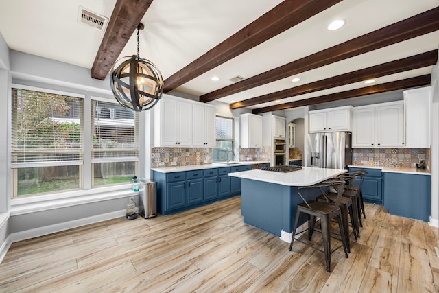 kitchen featuring visible vents, an inviting chandelier, appliances with stainless steel finishes, and blue cabinetry