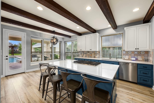 kitchen featuring white cabinetry, appliances with stainless steel finishes, decorative backsplash, and a sink